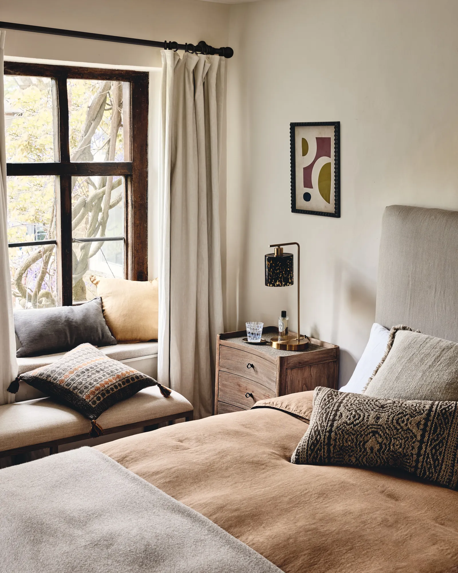 A wall-mounted folding bench providing a space-saving seating solution for a bedroom.