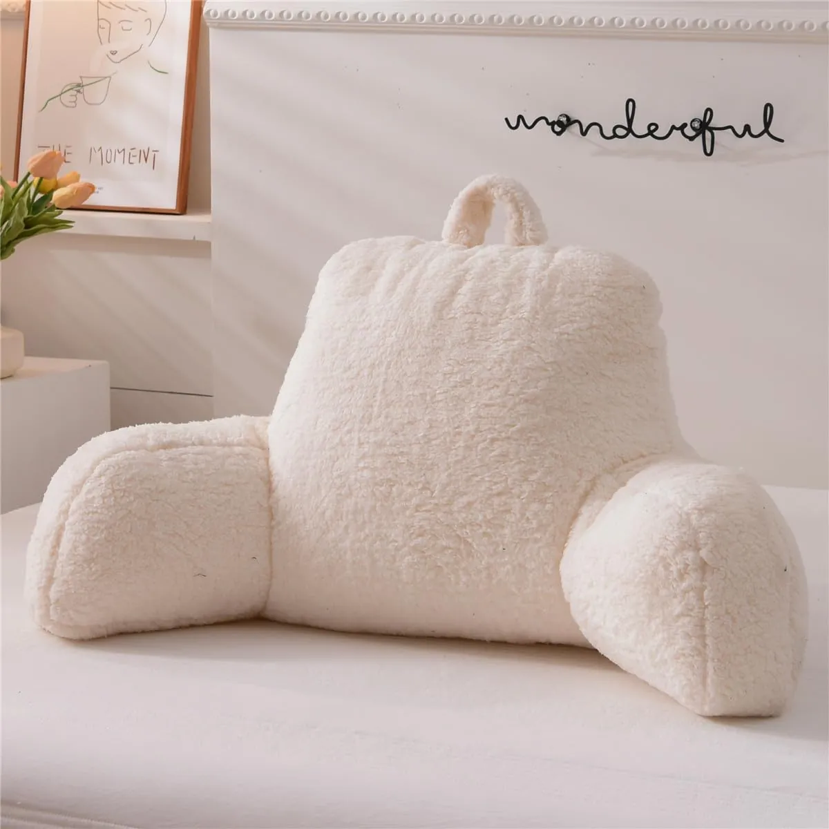 A worn flat pillow chair lies on a wooden floor showing fabric pilling.